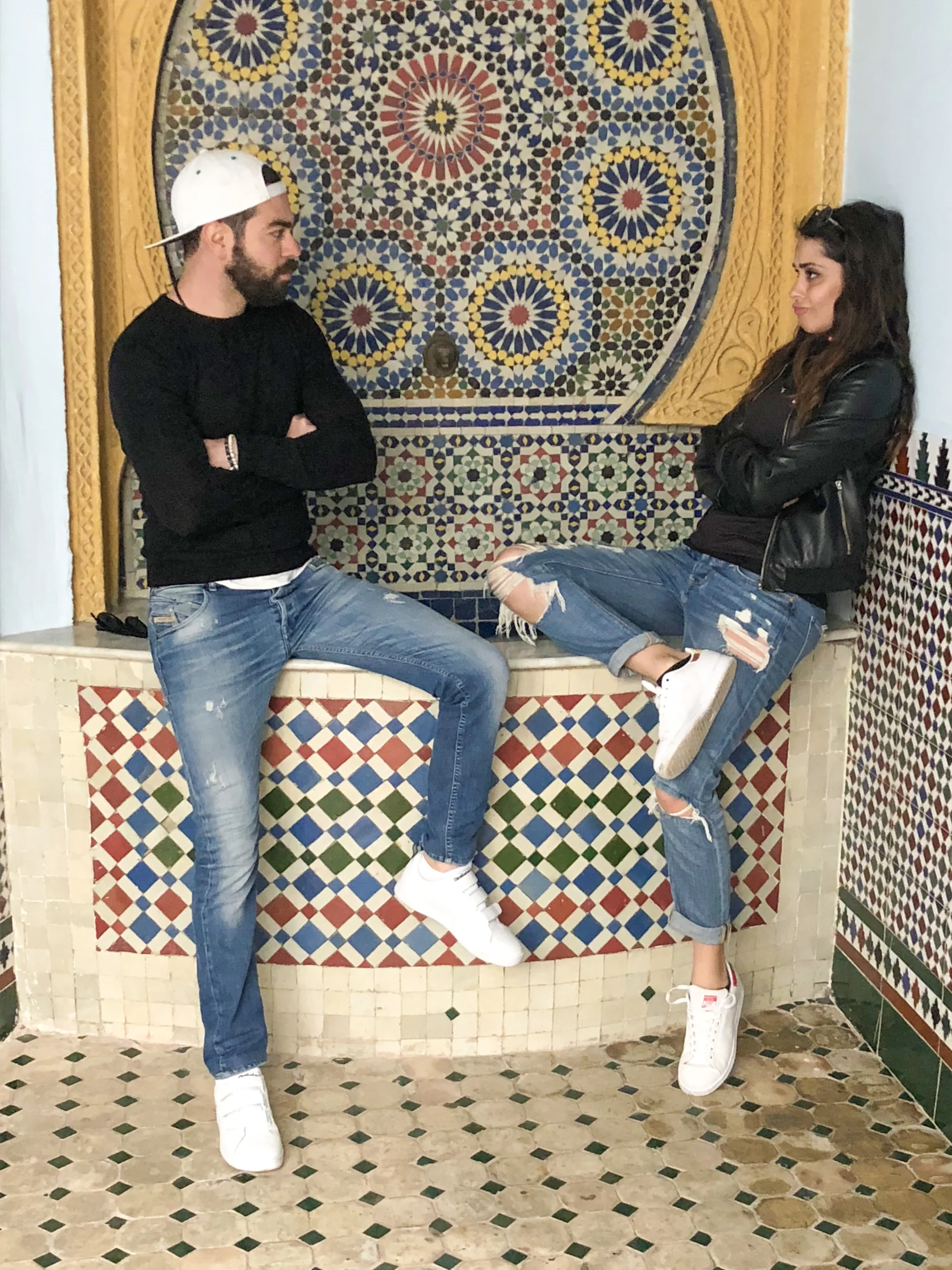 Nadah et Omar, fondateurs de la retraite bien-être Ômri au Maroc, posent devant une fontaine traditionnelle