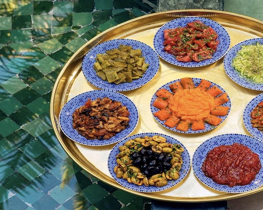 Assortiment de salades marocaines traditionnelles servies sur un plateau en laiton pendant un atelier culinaire à la retraite Ômri