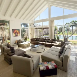 Salon lumineux et spacieux avec vue sur le jardin et la piscine, dans une villa de retraite bien-être au Maroc